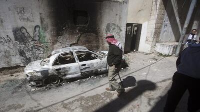 An elderly Palestinian man passes a burnt-out car as the funeral of Eyad Omar Sajdia takes place at the Qalandiya refugee camp, West Bank on March 1, 2016. Sajdia was killed as the Israeli army carried out an operation to rescue two Israeli soldiers who had accidently entered the camp in their military vehicle, causing riots. Atef Safadi/EPA