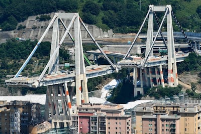 Two pylons of Genoa's collapsed Morandi bridge before their demolition, with red explosives placed on the structure. AFP