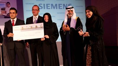 Sheikh Nahyan bin Mubarak, Minister of Culture, Youth and Community Development, and Dietmar Siersdorfer, the chief executive of Siemens Middle East, present the award to Team Cool Clay – (l-r) Majid Abuabdoun, Camilia Aokal and Fatima Al Madhloum – at the Siemens Student Awards in Abu Dhabi last night. Sammy Dallal / The National