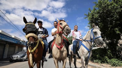 Palestinian youths ride horses in a street in Gaza City. AFP