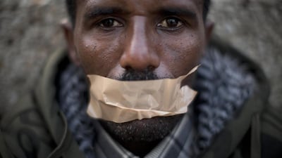 An African migrant covers his mouth with tape during a protest in Tel Aviv last year. Many migrants are from Eritrea and Ethiopia and are often given just 30 days to leave the country. Oded Balilty / AP Photo