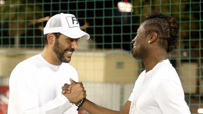 Asamoah Gyan shakes hands with Al Ahli chairman Abdullah Al Naboodah last Wednesday. Photo Courtesy / Al Ahli