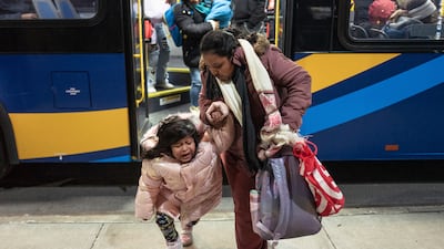 A migrant woman consoles her daughter as they leave a bus during their commute from Brooklyn to the Queens borough of New York. AP