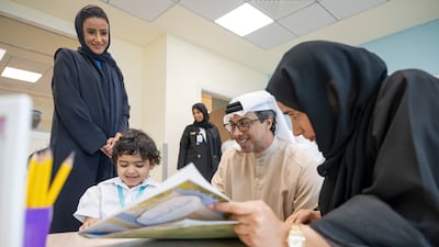 Sheikh Mansour interacts with a child as Ms Musallam, Minister of State for Early Education, looks on