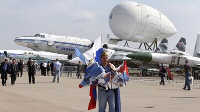 A vendor sells souvenirs while walking in front of an exhibition of old and rare airplanes. Sergei Chirikov / EPA