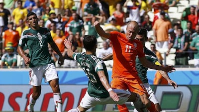 Arjen Robben, second right, of the Netherlands is challenged by Mexico's Hector Moreno, left, and Rafael Marquez during their 2014 World Cup round of 16 match on Sunday in Fortaleza, Brazil. Marcelo Del Pozo / Reuters
