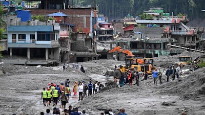 Workers use excavators to clear the mud at the Dhunge Bazaar in Nepal's Nuwakot district after flash floods and landslides hit the Nepal-Tibet border. AFP