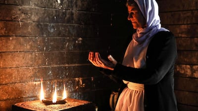 An Iraqi Yazidi woman prays at the Temple of Lalish, in a valley near the Kurdish city of Dohuk about 430km northwest of the capital Baghdad, on July 16, 2019. AFP