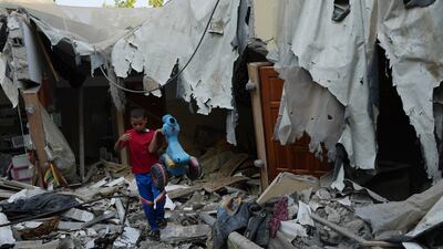 Mohammad Arada removes a tricycle from the rubble of his home after it was destroyed by an Israeli air strike, in the Rafah refugee camp. AP