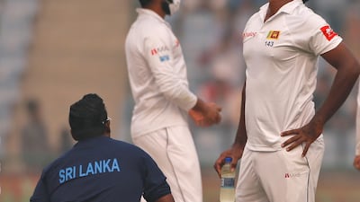 Sri Lanka's Lahiru Gamage, right, reacts as the game was briefly stopped during the second day of their third test cricket match in New Delhi. Altaf Qadri / AP Photo