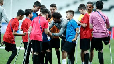 Liverpool's Mohamed Salah signs autographs for children at the end of a training session at the Besiktas Park Stadium, in Istanbul. AP Photo