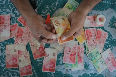 Worn and torn coins and notes in a marketplace in Deir al Balah, Gaza. With very limited money flowing into Gaza under Israeli attacks, most of the paper money used is worn and torn. Getty Images