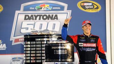Trevor Bayne, the Sprint Cup series driver , stands next to the trophy in Victory Lane after winning the Daytona 500.