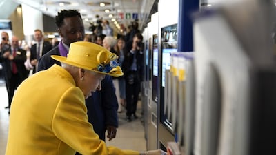 Queen Elizabeth using a oyster card machine at Paddington station. PA