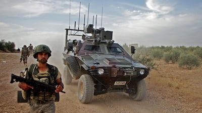 Turkish troops walk alongside an armoured personnel carrier through the town of Tukhar, north of Syria's northern city of Manbij, as Turkey and it's allies continues their assault on Kurdish-held border towns in northeastern Syria. Turkey wants to create a roughly 30-kilometre (20-mile) buffer zone along its border to keep Kurdish forces at bay and also to send back some of the 3.6 million Syrian refugees it hosts. AFP