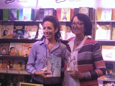 Taghreed and her daughter, Salwa, at their book stand with the Etisalat award and 'Whose Doll is This?' book. Courtesy Taghreed Najjar