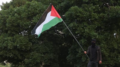 A man holds a Palestinian flag as mourners gather during the funeral. Reuters
