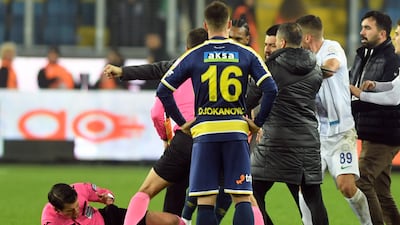 Referee Halil Umut Meler falls down after being punched by Ankaragucu president Faruk Koca. AP