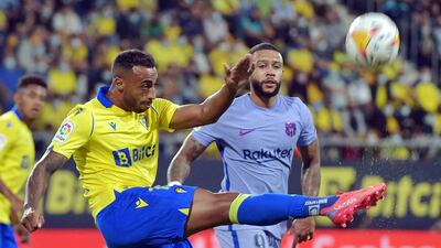 Cadiz defender Carlos Akapo kicks the ball next to Memphis Depay. AFP