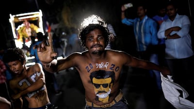 A fan with his body painted with image of Rajinikanth dances. Reuters