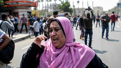 An Egyptian woman runs for cover after the first of three bomb blasts struck a police post at Cairo University on April 2, 2014. Mohamed El-Shahed / AFP