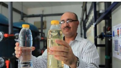 Raid al Essa, the maintenance manager at Al Ain Farms, shows the waste water after recycling, left, and before, right.