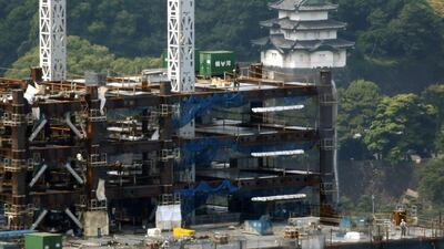 Labourers work at a construction site for a new commercial building near the Imperial Palace in Tokyo. A strengthening of the yen is eroding corporate profits for firms that work mostly overseas. Toru Hanai/Reuters