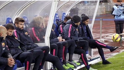 Barcelona's Dani Alves, right, Lionel Messi, second left and Gerard Pique, third left, sit on the bench during the first half of a 1-0 La Liga loss to Real Sociedad on Sunday night. Javier Etxezarreta / EPA / January 4, 2015