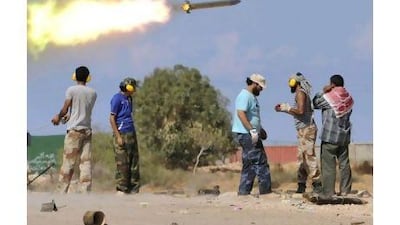 Libyan revolutionary fighters fire a missile during an attack on the city of Sirte yesterday. Bela Szandelszky / AP Photo
