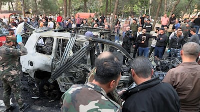 Syrian soldiers and civilians inspect the site of an air strike in the Mazzeh neighbourhood of Damascus on Monday. Israel claimed to have killed the head of Hezbollah's money transfer unit in the attack. EPA