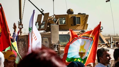 A soldier sits atop an armoured vehicle during a demonstration by Syrian Kurds against Turkish threats at a US-led international coalition base. AFP