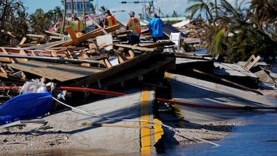Responders from the de Moya Group look at damage to the bridge. AP