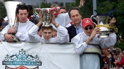 In this file photo taken on May 20, 2001 Liverpool's French coach Gerard Houllier, second right, defender Sami Hyypia, left, striker Robbie Fowler and Steven Gerrard, second right, show off their three trophies from an open top bus during a parade through the city of Liverpool. AFP