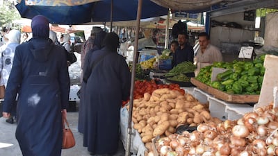 Syrians shop for vegetables at a market in Damascus on Sunday July 11, hours after Syrian President Bashar Al Assad issued a legislative decree granting civil servants and military members a 50 per cent pay rise. The decision comes a day after the government raised the price of fuel by more than 50 per cent for the third time this year. EPA