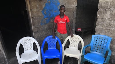 Mohammed Kromah, an Ebola survivor, poses for a family portrait at his home in West Point, Monrovia, Liberia. The empty chairs symbolise his wife and children, who died of the Ebola virus during an outbreak of the disease in 2014. Ahmed Jallanzo / EPA