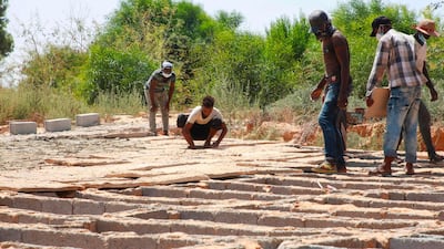 Workers burry the bodies of migrants, who died in a shipwreck off the coast of Khoms, at a communal cemetery in Libya's capital suburb of Tajoura. AFP