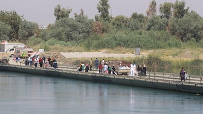 Iraqis walk across Victory Bridge, Mosul's only crossing over the Tigris River, on July 21, 2017. Khalid Al Mousily / Reuters