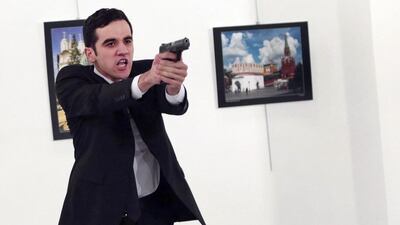 A man identified as Mevlut Mert Altintas holds up a gun after shooting Andrei Karlov, the Russian Ambassador to Turkey. Burhan Ozbilici / AP Photo