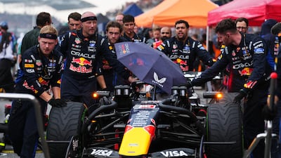 Mechanics push Max Verstappen's Red Bull to its grid slot. Getty Images