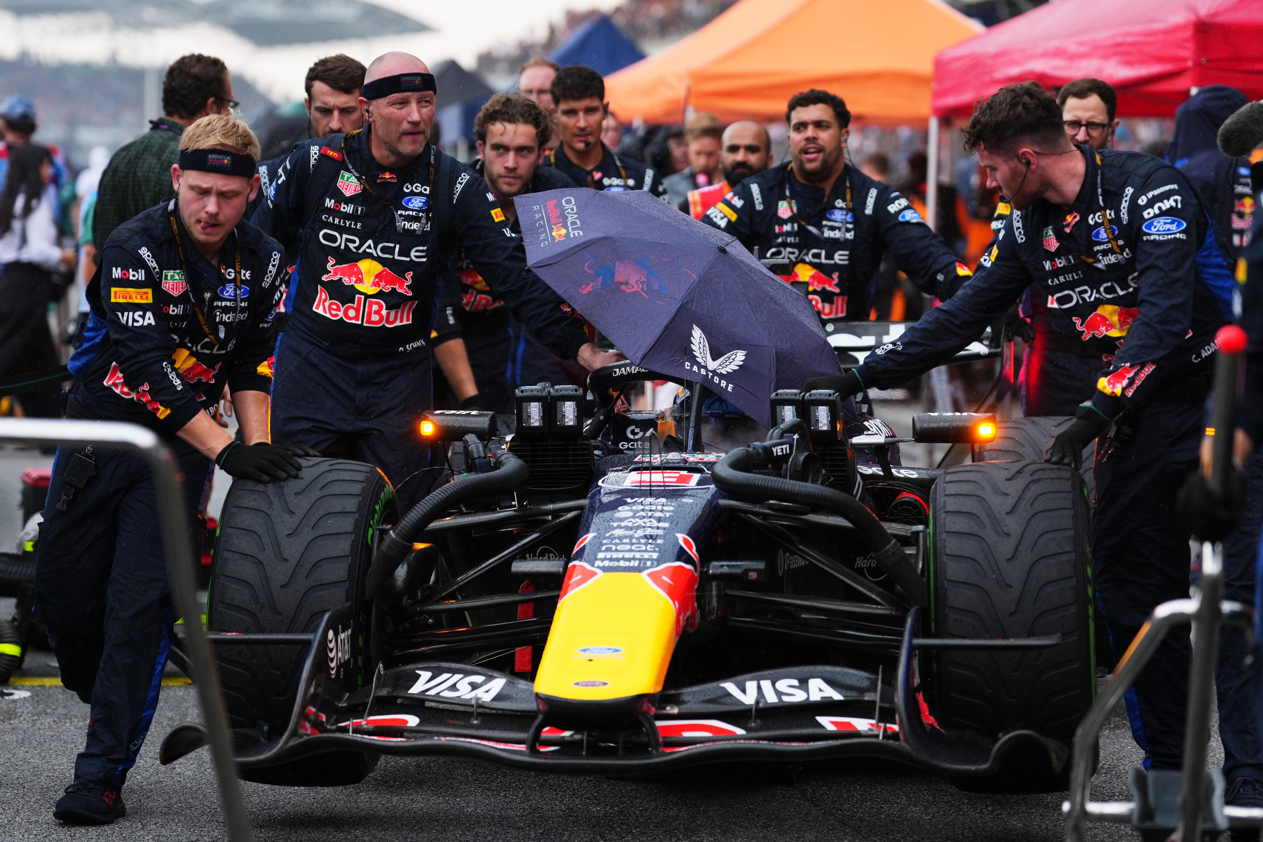Mechanics push Max Verstappen's Red Bull to its grid slot. Getty Images