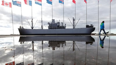 A man walks past flags and a vessel model during the preparation for festive ceremonies commemorating the 75th anniversary of the arrival of the first allied Arctic Convoy, codenamed Operation Dervish, at the northern port of the Soviet Union during the Second World War in Arkhangelsk, Russia. Maxim Zmeyev / Reuters