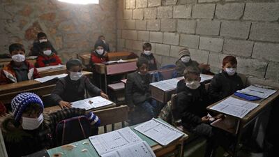 Syrian schoolchildren wearing masks sit in a makeshift school set up by locals in the village of Ma'arin, in the rebel-controlled northern countryside of Syria's Aleppo province.