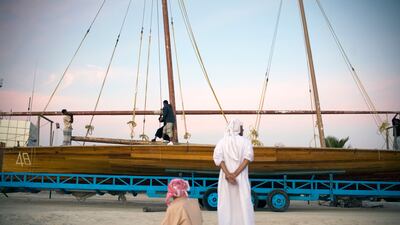Men work on a dhow racing boat. The National