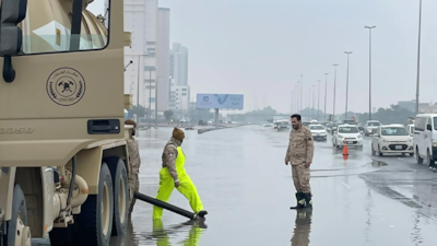 Municipal workers try to drain a road. Kuwait News Agency