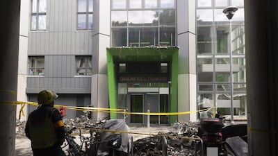 A firefighter stands outside the Grenfell Tower in London. Metropolitan Police via AP Photo
