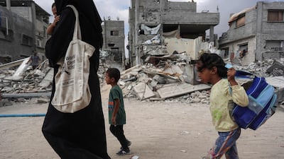 A Palestinian woman with her children among the ruins of Khan Younis in the southern Gaza Strip on July 14, 2024. AFP