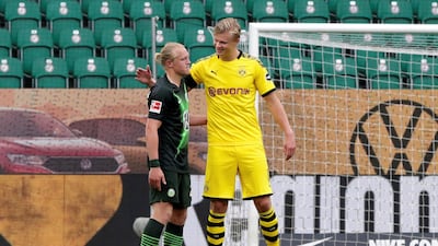 Borussia Dortmund's Erling Haaland greets Wolfsburg's Xaver Schlager. Reuters