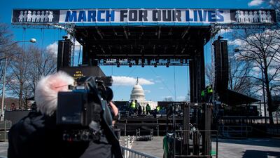 A cameraman films construction workers setting up the March For Our Lives stage ahead of the anti-gun rally in Washington, DC, on March 23, 2018. Andrew Caballero-Reynolds / AFP Photo