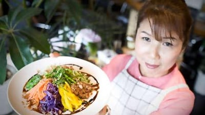 Mayumi Nishimura, who believes we should eat whole grains and local vegetables and argues that food should be chewed 30 times, holds up a soba salad.
