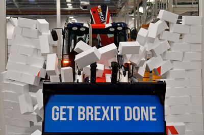 Boris Johnson drives a forklift through a symbolic wall with the Conservative Party slogan 'Get Brexit Done' during an election campaign event in December. Mr Johnson has now declared Brexit officially "done". Ben Stansal l/ Pool via AP